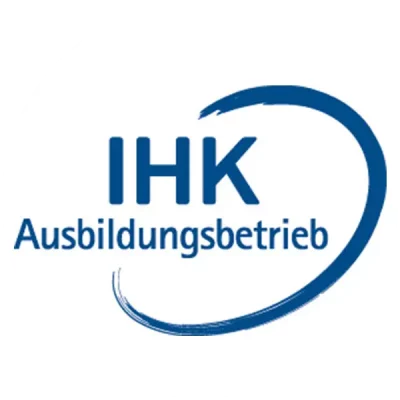 Rundes Logo mit blauem Schriftzug „IHK Ausbildungsbetrieb“; rechts daneben verläuft ein breiter, halbkreisförmiger Pinselzug in dunklerem Blau, der die Worte optisch umrahmt. Das Zeichen signalisiert, dass der Betrieb offiziell von der Industrie- und Handelskammer als Ausbildungsbetrieb anerkannt ist.