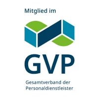 Rundes Logo mit der Aufschrift „Mitglied im GVP – Gesamtverband der Personaldienstleister“. Oberhalb des Schriftzugs befindet sich eine geometrische, aus blauen und grünen Flächen zusammengesetzte Form, die an miteinander verbundene Bausteine oder ein stilisiertes Netzwerk erinnert. Das Logo signalisiert die Verbandszugehörigkeit eines Unternehmens im Bereich Personaldienstleistungen.